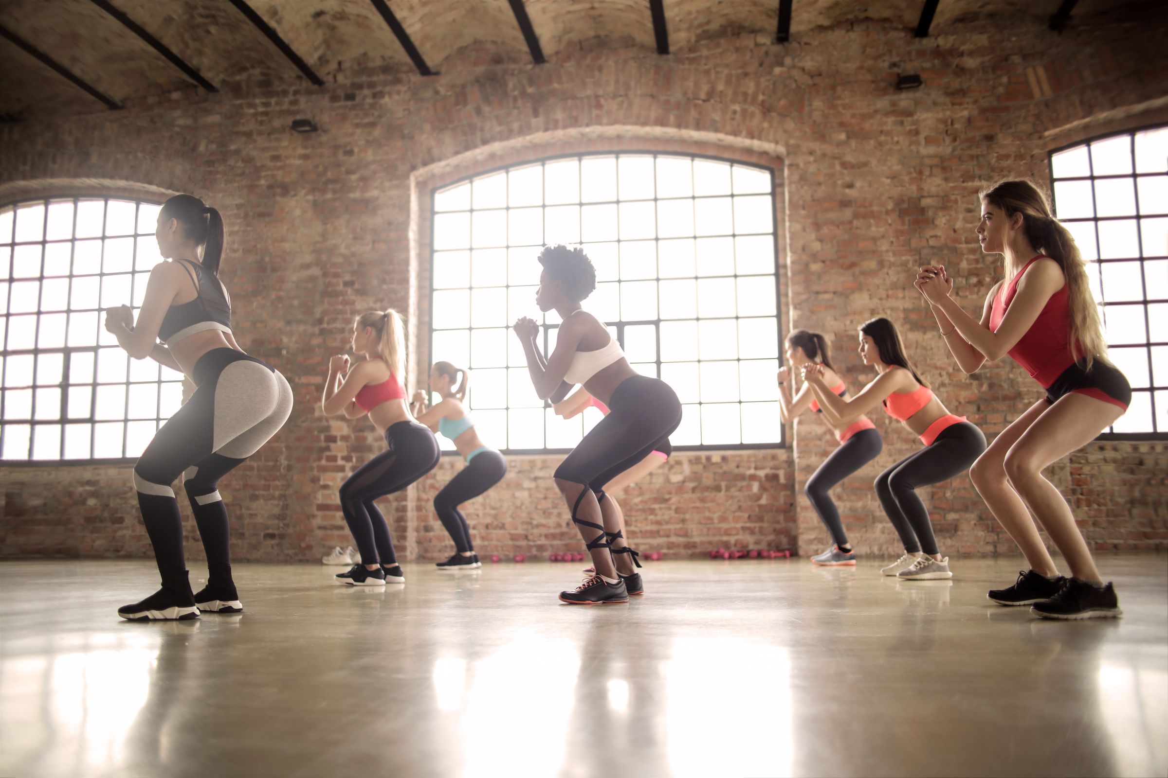 Group class doing squats in a loft studio