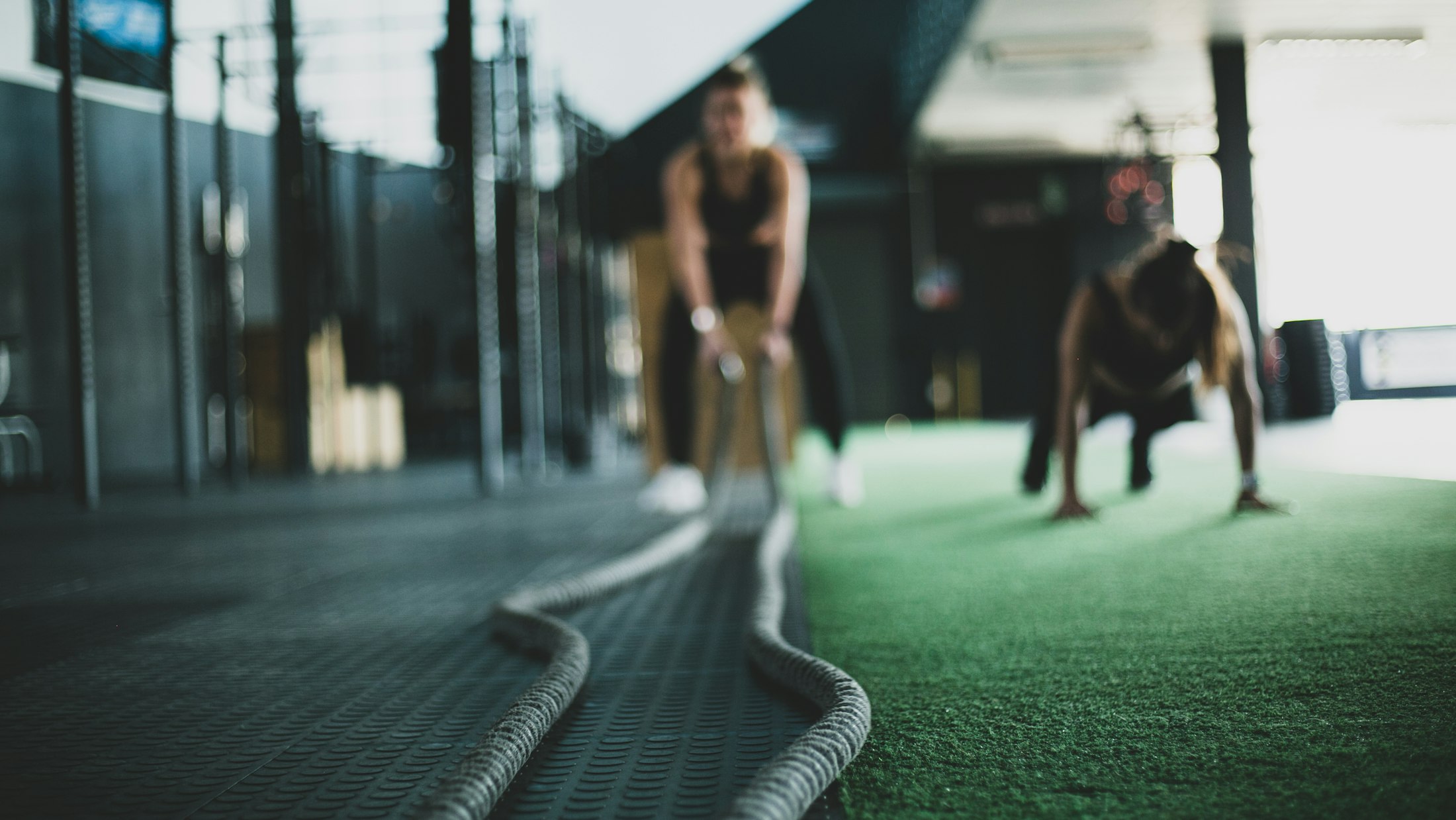 Athletes pushing battle ropes in a premium performance gym